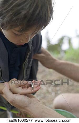 Stock Photo - Boy caught tiny fish. Fotosearch