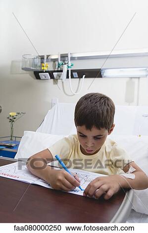Stock Image - Boy coloring in hospital bed. Fotosearch