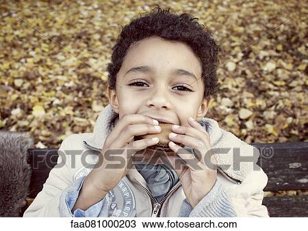 Boy eating macaroon, portrait View Large Photo Image Stock Image - Boy eating macaroon, portrait. Fotosearch