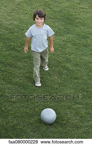 Stock Photo - Boy playing with ball outdoors. Fotosearch