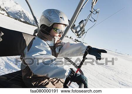 Boy riding ski lift at ski resort View Large Photo Image Stock Image - Boy riding ski lift at ski resort. Fotosearch