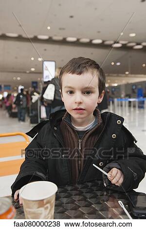 Boy taking break at cafe table View Large Photo Image Stock Photo - Boy taking break at cafe table. Fotosearch