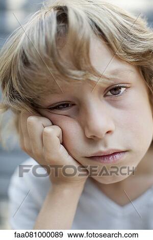 Stock Photo - Boy with bored expression on face, portrait. Fotosearch