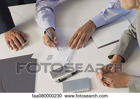 Stock Image - Business associates brainstorming together, cropped. Fotosearch