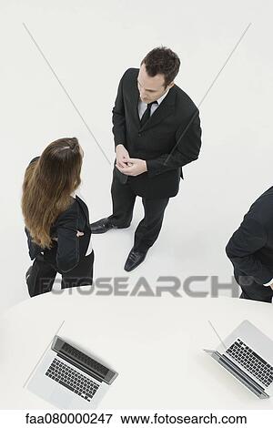 Business associates chatting View Large Photo Image Stock Photo - Business associates chatting. Fotosearch