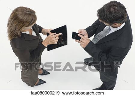 Stock Photo - Business associates exchanging information with wireless devices. Fotosearch