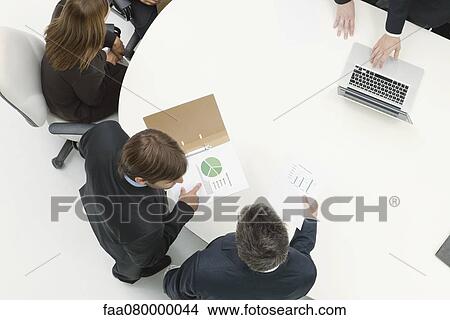 Picture - Business associates reviewing documents. Fotosearch