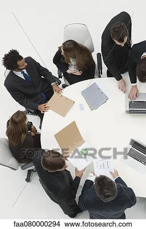 Picture - Business associates reviewing documents together. Fotosearch