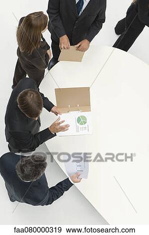 Stock Photo - Business associates reviewing documents. Fotosearch