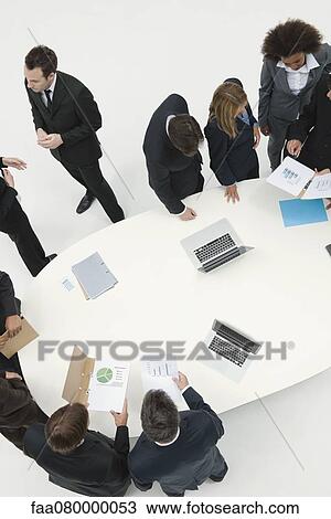Business associates working together in small groups around table View Large Photo Image Stock Image - Business associates working together in small groups around table. Fotosearch