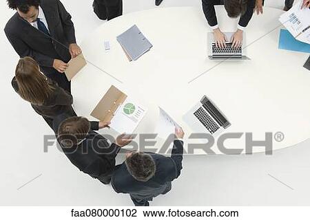 Business associates working together reviewing document View Large Photo Image Stock Image - Business associates working together reviewing document. Fotosearch