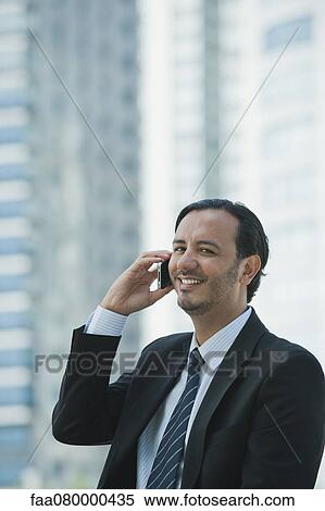 Business executive using cell phone outdoors View Large Photo Image Stock Photography - Business executive using cell phone outdoors. Fotosearch