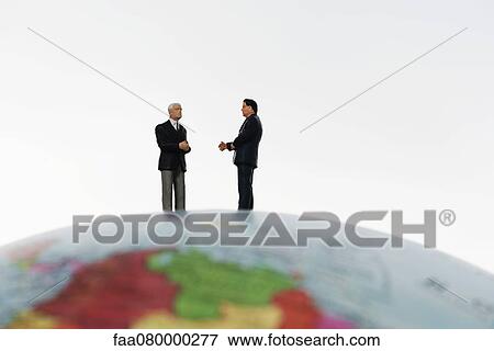 Businessman figurines standing on top of globe View Large Photo Image Stock Photo - Businessman figurines standing on top of globe. Fotosearch