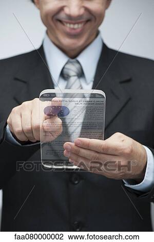 Stock Image - Businessman reading news on advanced digital tablet, cropped. Fotosearch