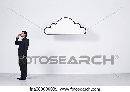 Stock Photography - Businessman talking on cell phone near graphic cloud representing cloud computing. Fotosearch