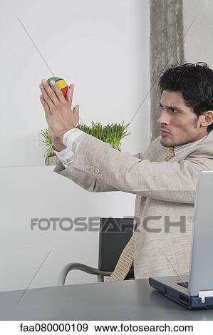 Businessman throwing toy ball in office View Large Photo Image Stock Photo - Businessman throwing toy ball in office. Fotosearch