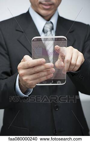 Stock Image - Businessman using advanced digital tablet to access stock market data, cropped. Fotosearch