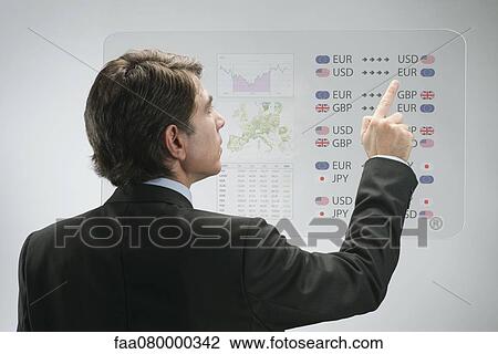 Stock Image - Businessman using advanced touch screen technology to view business data. Fotosearch