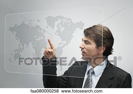 Stock Photo - Businessman using advanced touch screen technology to view world map. Fotosearch