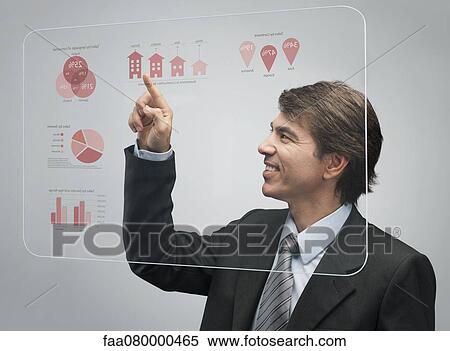 Stock Photography - Businessman using advanced touch screen technology to view sales data. Fotosearch