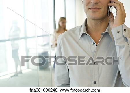 Businessman using cell phone in office View Large Photo Image Stock Photo - Businessman using cell phone in office. Fotosearch