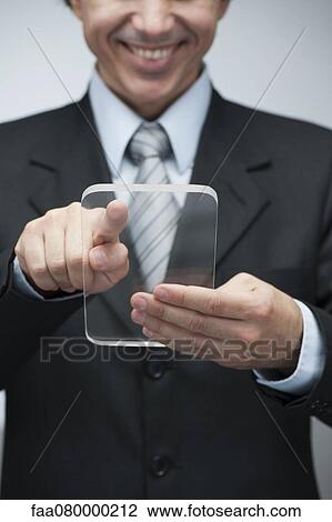 Businessman using transparent digital tablet View Large Photo Image Stock Image - Businessman using transparent digital tablet. Fotosearch