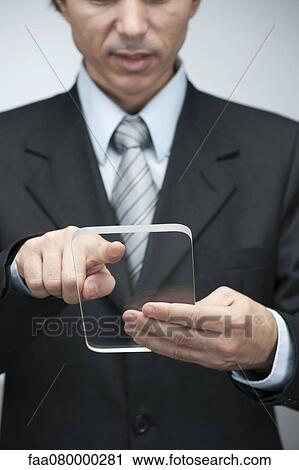 Stock Image - Businessman using transparent digital tablet. Fotosearch