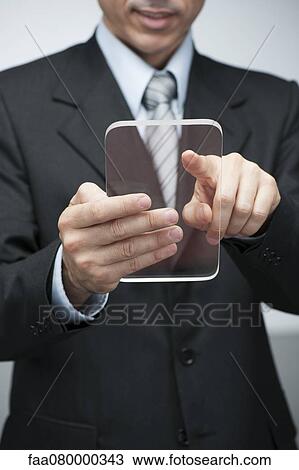 Stock Image - Businessman using transparent digital tablet. Fotosearch