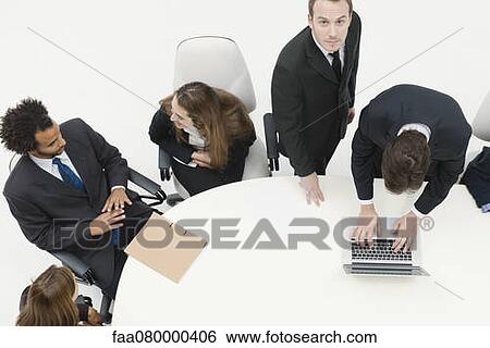 Businessman working with associates at meeting View Large Photo Image Stock Photograph - Businessman working with associates at meeting. Fotosearch