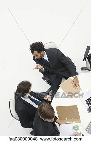 Stock Photo - Businessmen chatting at meeting. Fotosearch