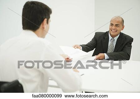 Businessmen discussing documents in meeting View Large Photo Image Stock Photo - Businessmen discussing documents in meeting. Fotosearch