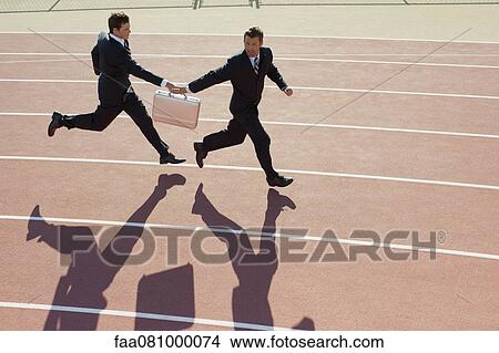 Businessmen passing briefcase while running on running track View Large Photo Image Picture - Businessmen passing briefcase while running on running track. Fotosearch