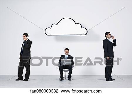 Stock Image - Businessmen using wireless devices with cloud computing network. Fotosearch