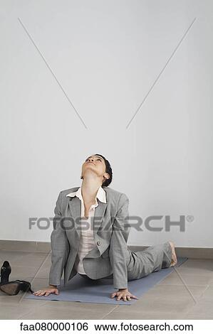 Stock Photograph - Businesswoman doing cobra pose in office. Fotosearch