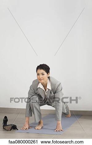 Businesswoman doing yoga in office View Large Photo Image Stock Image - Businesswoman doing yoga in office. Fotosearch