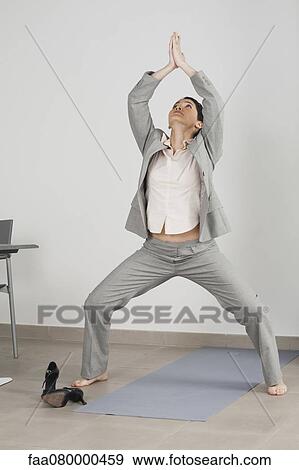 Businesswoman doing yoga in office View Large Photo Image Stock Photo - Businesswoman doing yoga in office. Fotosearch