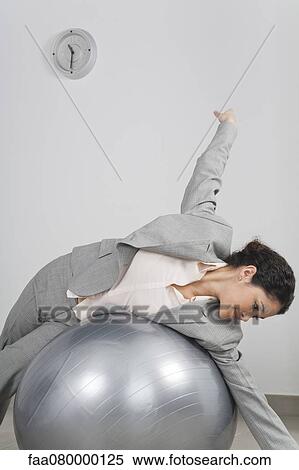 Businesswoman lying on top of fitness ball View Large Photo Image Stock Photography - Businesswoman lying on top of fitness ball. Fotosearch