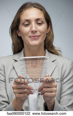 Stock Image - Businesswoman reading news using advanced digital tablet. Fotosearch