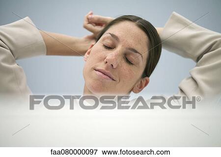 Businesswoman relaxing with hands behind head View Large Photo Image Stock Photo - Businesswoman relaxing with hands behind head. Fotosearch