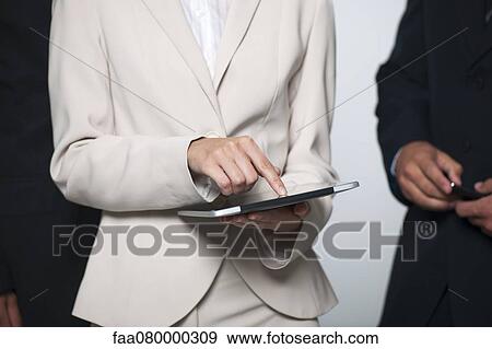 Businesswoman showing digital tablet to colleagues, cropped View Large Photo Image Stock Photo - Businesswoman showing digital tablet to colleagues, cropped. Fotosearch