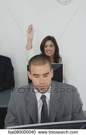 Stock Image - Businesswoman throwing paper airplane at male colleague. Fotosearch