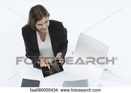 Businesswoman using digital tablet, high angle view View Large Photo Image Picture - Businesswoman using digital tablet, high angle view. Fotosearch