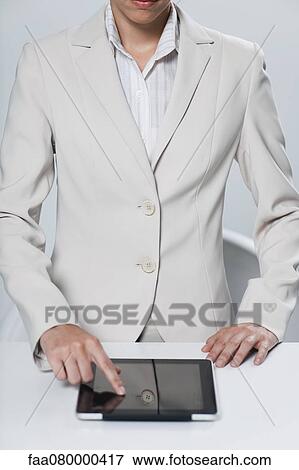 Stock Photo - Businesswoman using touch screen on digital tablet. Fotosearch