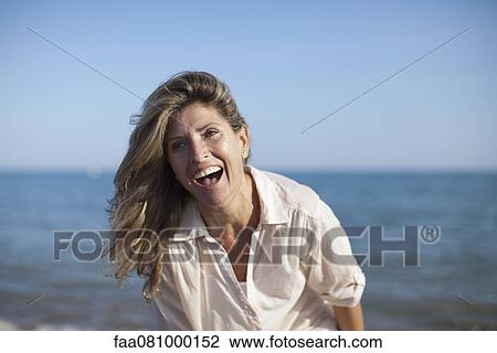 Stock Image - Carefree woman at the beach, portrait. Fotosearch