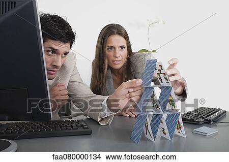 Picture - Colleagues building house of cards. Fotosearch