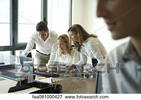 Colleagues collaborating in office View Large Photo Image Stock Photo - Colleagues collaborating in office. Fotosearch