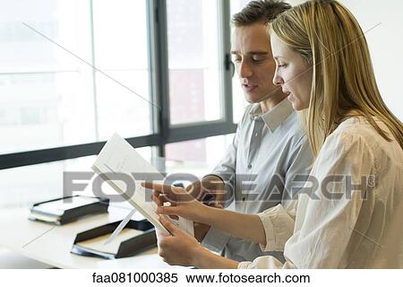 Stock Photography - Colleagues discussing blueprints. Fotosearch