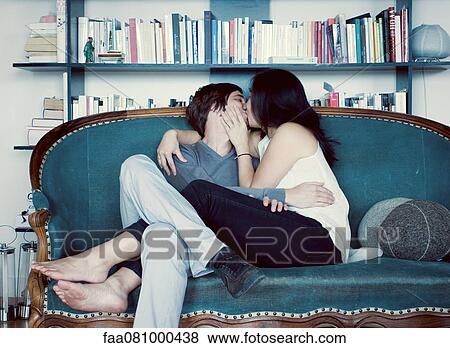 Stock Photo - Couple kissing on sofa. Fotosearch