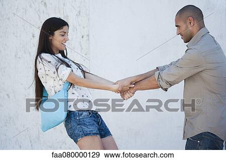 Stock Photo - Couple playing and holding hands. Fotosearch