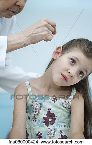 Doctor putting ear drops in girl's ear View Large Photo Image Picture - Doctor putting ear drops in girl's ear. Fotosearch
